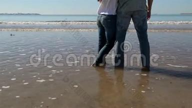 情侣拥抱背景海滩海洋日出。 人们拥抱和看待后景海景。 情侣享受日落